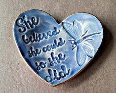 a blue heart with a butterfly on it that says she belongs the world to the person