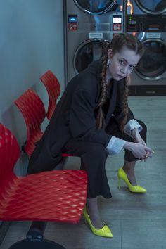 Editorial fashion photoshoot in a laundromat. Model wearing a black pant suit with neon high heels. Laundromat Photoshoot, 70s Photoshoot, Neon Heels, Photoshoot Editorial, Laundry Mat, References For Drawing, Editorial Photoshoot, Pose Inspiration