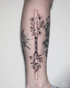 a woman's leg with a guitar and flowers tattoo on her left calf area