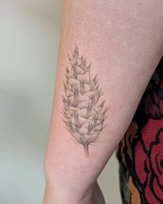 a black and white photo of a pineapple tattoo on the right arm, which has been drawn in pencil