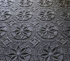 an old crocheted table cloth with circles and stars on the edges, in grey