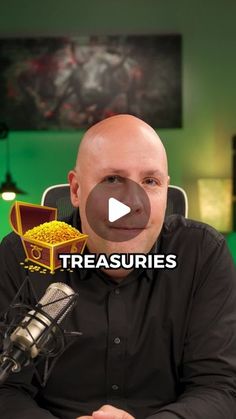 a bald man sitting in front of a microphone with the words treasures on top of it