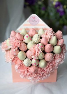 a bouquet of pink carnations and white chocolate candies in a candy box