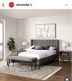 a bed sitting on top of a wooden floor next to a window