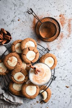 some cookies are sitting on a wire rack with cinnamons and an ice cream in the middle