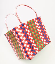 This charming 1970s style accessory features a vibrant color combo of red, green, blue, and white that screams retro chic. The durable plastic material ensures this bag will be your go-to for all your sunny day outings. With convenient plastic handles, you can easily carry all your essentials in style.Available while supplies last. Retro Red Bags For Summer, Retro Red Summer Bag, Retro Red Summer Bags, Retro Red Square Bag, Red Retro Square Bag, Playful Red Summer Bags, Multicolor Plastic Travel Bag, Fun Multicolor Plastic Bags, Multicolor Plastic Bag For Everyday Use