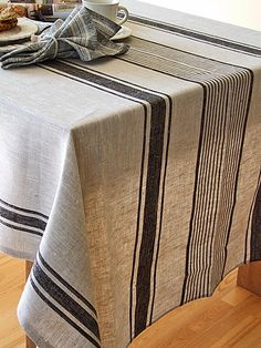 a table with a striped cloth on it and a cup of coffee next to it