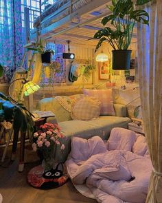 a living room filled with lots of furniture next to plants and flowers on the floor