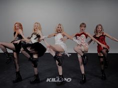 four women in short skirts and boots are posing for a photo with their legs spread out