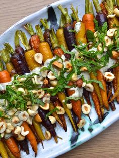 carrots and other vegetables on a platter with cashews, nuts and parsley