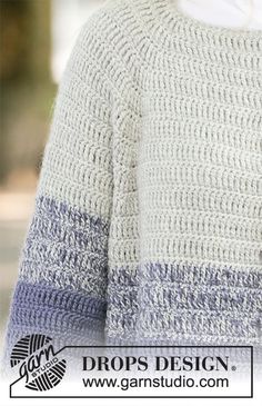 a close up of a person wearing a white sweater with blue and gray stripes on it