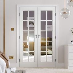 a bedroom with white walls and glass doors