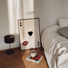 a bed room with a poster on the wall next to a lamp and a book