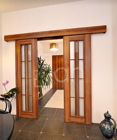 an open door leading to a hallway with potted plants