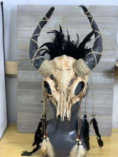 an animal's head with horns and feathers on it