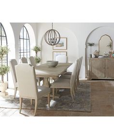 a dining room table with chairs and a rug on the floor