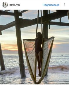 a woman is sitting in a hammock on the beach