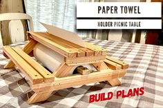 a wooden table with a roll of toilet paper in it and the words, paper towel holder picnic table