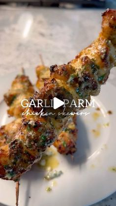 a white plate topped with food on top of a wooden skewer and text that reads garli parm