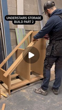 a man standing in front of a wooden structure with the words under stairs storage build part 2