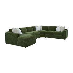 a large green sectional couch with pillows on it's back and side facings