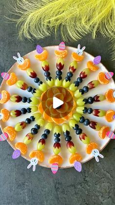 a plate with some fruit on it and a yellow feather next to it that says happy easter