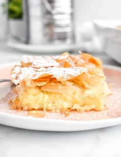 a piece of cake sitting on top of a white plate with powdered sugar around it