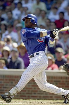 a baseball player is swinging his bat at the ball while people watch from the stands