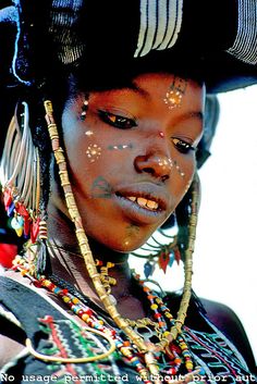 a woman with jewelry on her face and the words melanin above her head