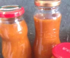 three jars filled with orange sauce sitting on top of a counter next to each other