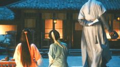 three women in kimonos are standing outside at night