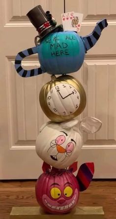 three pumpkins stacked on top of each other in front of a door with words written on them