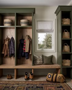 a wooden bench sitting under a window next to a rug