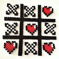 a black and white square with red hearts on it's sides is made out of legos