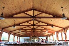 the inside of a building with tables and people standing around in front of it,