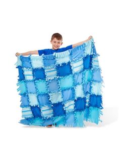 a young boy holding up a blue and white blanket with ruffles on it