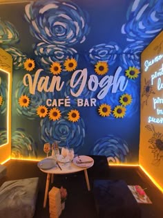 a cafe with sunflowers painted on the wall and tables in front of it