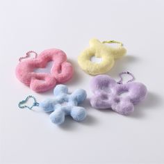 four different colored hair clips on a white surface