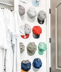 several hats are hanging on the wall next to a white door