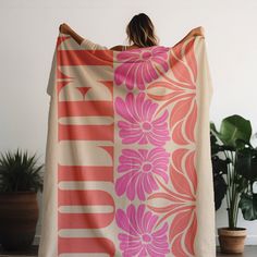 a woman is wrapped up in an orange and pink flowered blanket with the word love on it