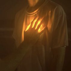 a person holding their hands up in the dark