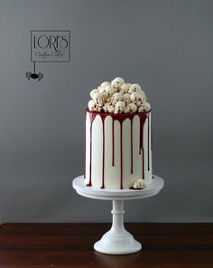 a white and red cake with chocolate drizzles on it sitting on a table