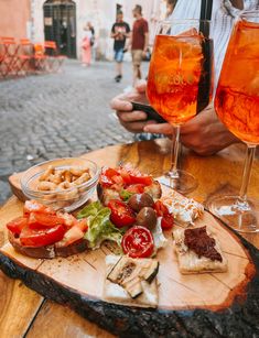 two glasses of wine and some food on a table