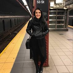 a woman standing next to a train station platform