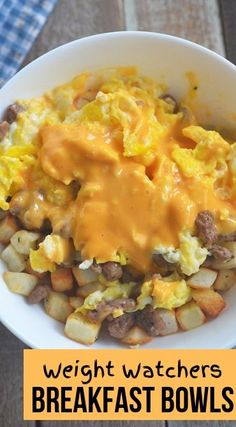 a white bowl filled with eggs and potatoes covered in gravy on top of a wooden table