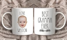 two white coffee mugs with the words love best gramma ever and an image of a baby's face