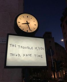 a clock on top of a sign that says the trouble is you think have time