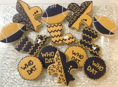 some decorated cookies are sitting on a clear plate with black and yellow decorations around them