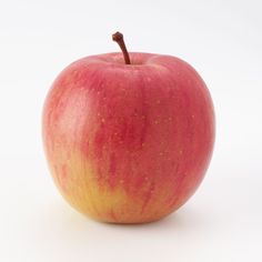 an apple with yellow speckles on it's skin is sitting in front of a white background