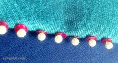 several different colored beads on the side of a piece of blue fabric with red and white dots